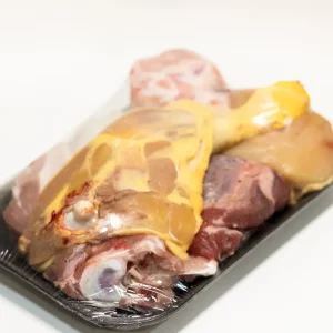 Ingredientes frescos para preparado de caldo casero: verduras, huesos y hierbas aromáticas listos para cocer.