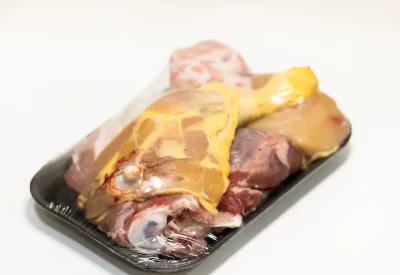 Ingredientes frescos para preparado de caldo casero: verduras, huesos y hierbas aromáticas listos para cocer.