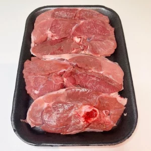 Bandeja con trozos de pierna de cordero cruda Aluju, de color rojo intenso y veteado natural, listos para cocinar.