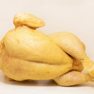 Un pollo entero dorado y crujiente servido en una bandeja con guarnición de patatas y verduras.