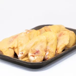Un plato de alitas de pollo doradas y crujientes, acompañadas de salsa barbacoa y apio fresco.
