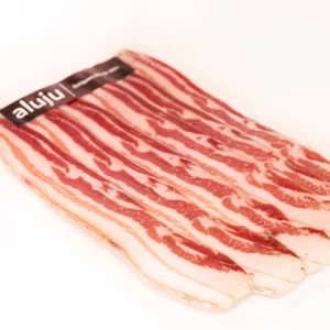 "Lonchas de tocino ibérico con vetas doradas y una textura untuosa."