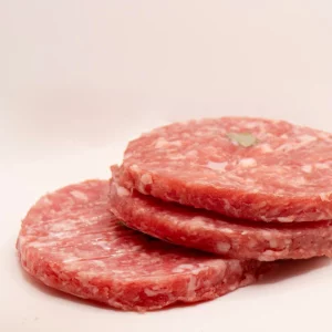 "Hamburguesa de cerdo recién cocinada, mostrando su textura jugosa y dorada."