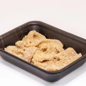 Un plato de lágrimas de pollo doradas y crujientes, acompañadas de salsa barbacoa y una guarnición de patatas fritas.