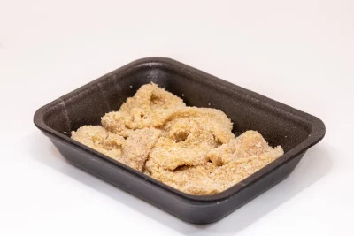 Un plato de lágrimas de pollo doradas y crujientes, acompañadas de salsa barbacoa y una guarnición de patatas fritas.