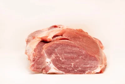 Trozo de magra de cuello de cerdo cruda, destacando su textura veteada y su frescura.