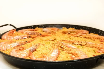 "Plato de paella con mariscos, arroz dorado y un fondo ligeramente caramelizado."