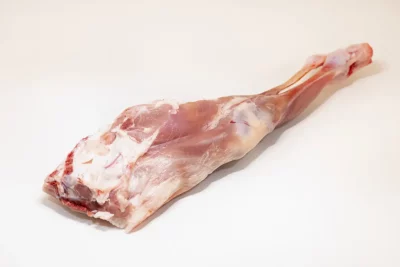 "Pierna de cabrito asada al horno con hierbas aromáticas, mostrando su textura dorada y jugosa."