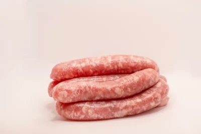 "Salchichas doradas a la parrilla, mostrando su textura jugosa y aroma irresistible."