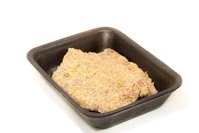 Un plato de ternera rebozada recién hecha, con su capa dorada y crujiente, acompañado de patatas fritas y una ensalada fresca.