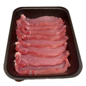Filetes de lomo de cerdo dorados a la plancha, servidos con ajo y perejil sobre plato rústico.