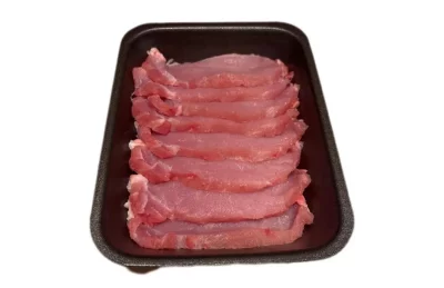 Lomo a filetes: la receta fácil, jugosa y llena de sabor Filetes de lomo de cerdo dorados a la plancha, servidos con ajo y perejil sobre plato rústico.