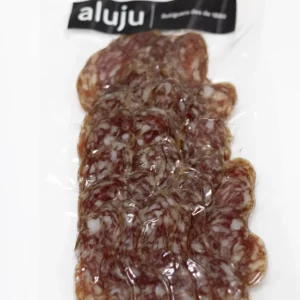 Longaniza de Caldes: tradición embutida con sabor catalán Longaniza de Caldes curada artesanalmente, con especias naturales, presentada en tabla rústica con pan y aceitunas.