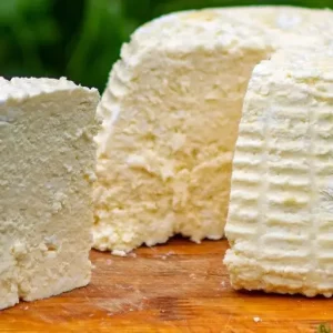 Queso fresco de cabra Queso fresco de cabra en porciones, con su textura cremosa y color blanco puro, listo para degustar.