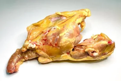 Carcasa de pollo cruda Aluju, limpia y lista para cocinar, con huesos visibles y restos de carne, ideal para caldos caseros.