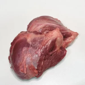 Galtas de cerdo Aluju cocinadas a fuego lento, servidas con salsa de vino tinto y guarnición de patatas, sobre plato rústico.