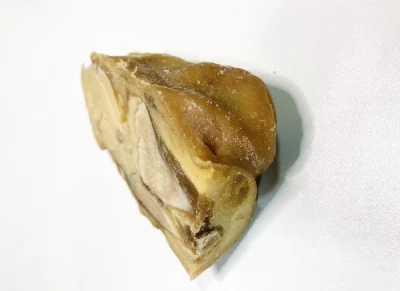 Hueso de jamón Aluju: sabor profundo en cada receta casera Hueso de jamón curado con restos de carne, envase transparente, ideal para enriquecer platos tradicionales.