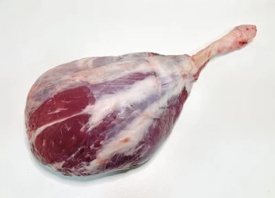 Pieza de llata de ternera Aluju cruda, con hueso y veteado natural, presentada en bandeja, lista para guisar o asar lentamente.