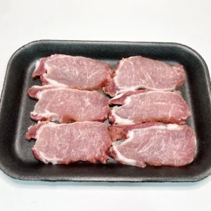 Bandeja con piezas de lomo ibérico crudo Aluju, de aspecto marmoleado y color rojizo, listas para cocinar.