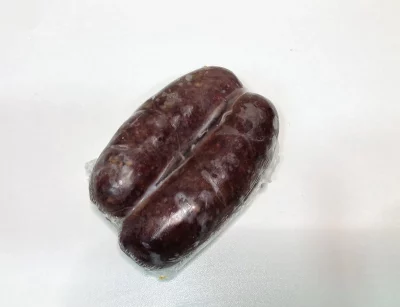 Morcilla Aluju envasada al vacío, de color oscuro y textura compacta, presentada en pack doble sobre fondo neutro.