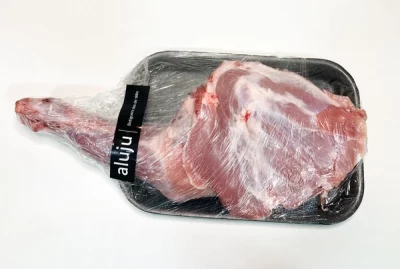 Paletilla de cordero Aluju: sabor noble para asados con alma Paletilla de cordero Aluju cruda, envasada en bandeja negra y envuelta en plástico transparente, lista para cocinar al horno o a la brasa.