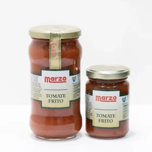Dos frascos de Tomate Frito Marzo con tapa dorada y etiqueta roja, uno grande y otro pequeño, sobre fondo blanco, que representan calidad y tradición riojana.