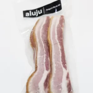 Torreznos de Soria Aluju: tradición crujiente con sello de calidad Paquete al vacío con dos tiras de torreznos de Soria Aluju, con carne rosada y grasa blanca, listos para freír y disfrutar.