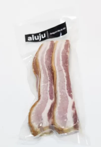 Paquete al vacío con dos tiras de torreznos de Soria Aluju, con carne rosada y grasa blanca, listos para freír y disfrutar.
